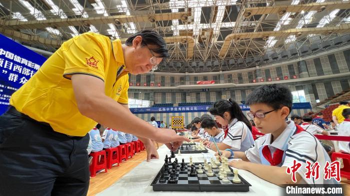 图为国际象棋男子国际特级大师叶江川与小棋手上演“一对多车轮战”表演。　肖江川 摄